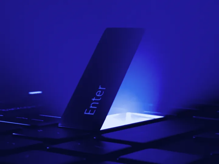 Close-up of a keyboard&rsquo;s Enter key, lit in blue