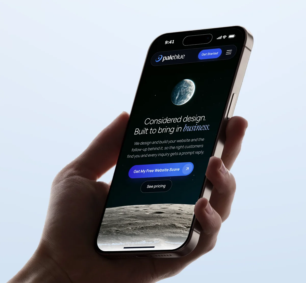 The Pale Blue homepage on a phone held in a hand